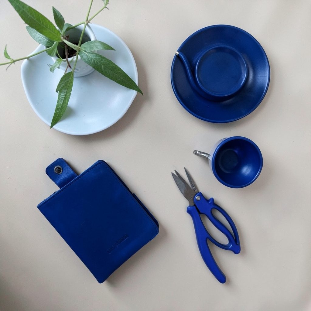 Overhead flat-lay of a bright desk with notebooks, a coffee cup, and colorful pens, warm and inviting creative workspace